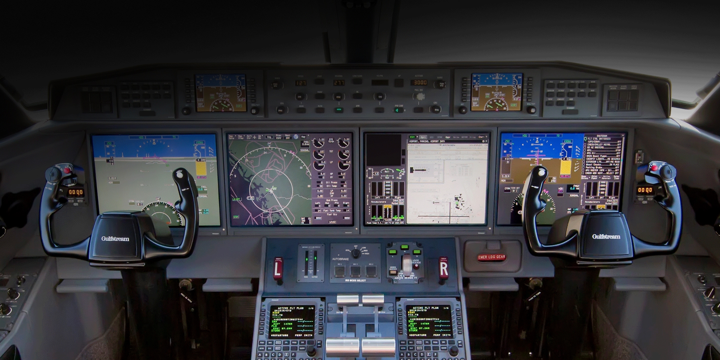 The cockpit of an airplane featuring multiple control screens and instruments for navigation and flight management