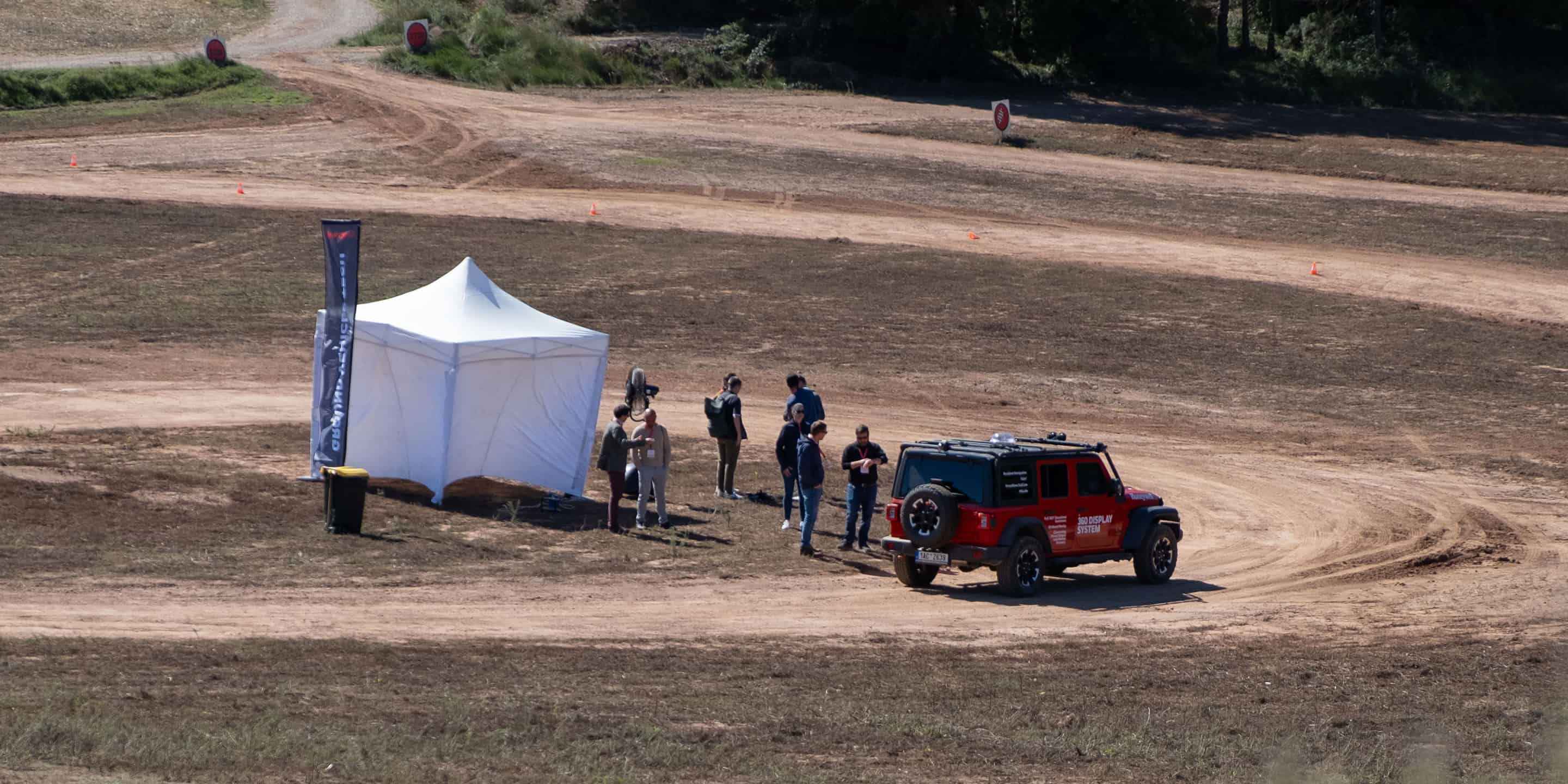 HON Aero off-road vehicle positioned near a white canopy as team members prepare for outdoor testing and collaborative field activities.