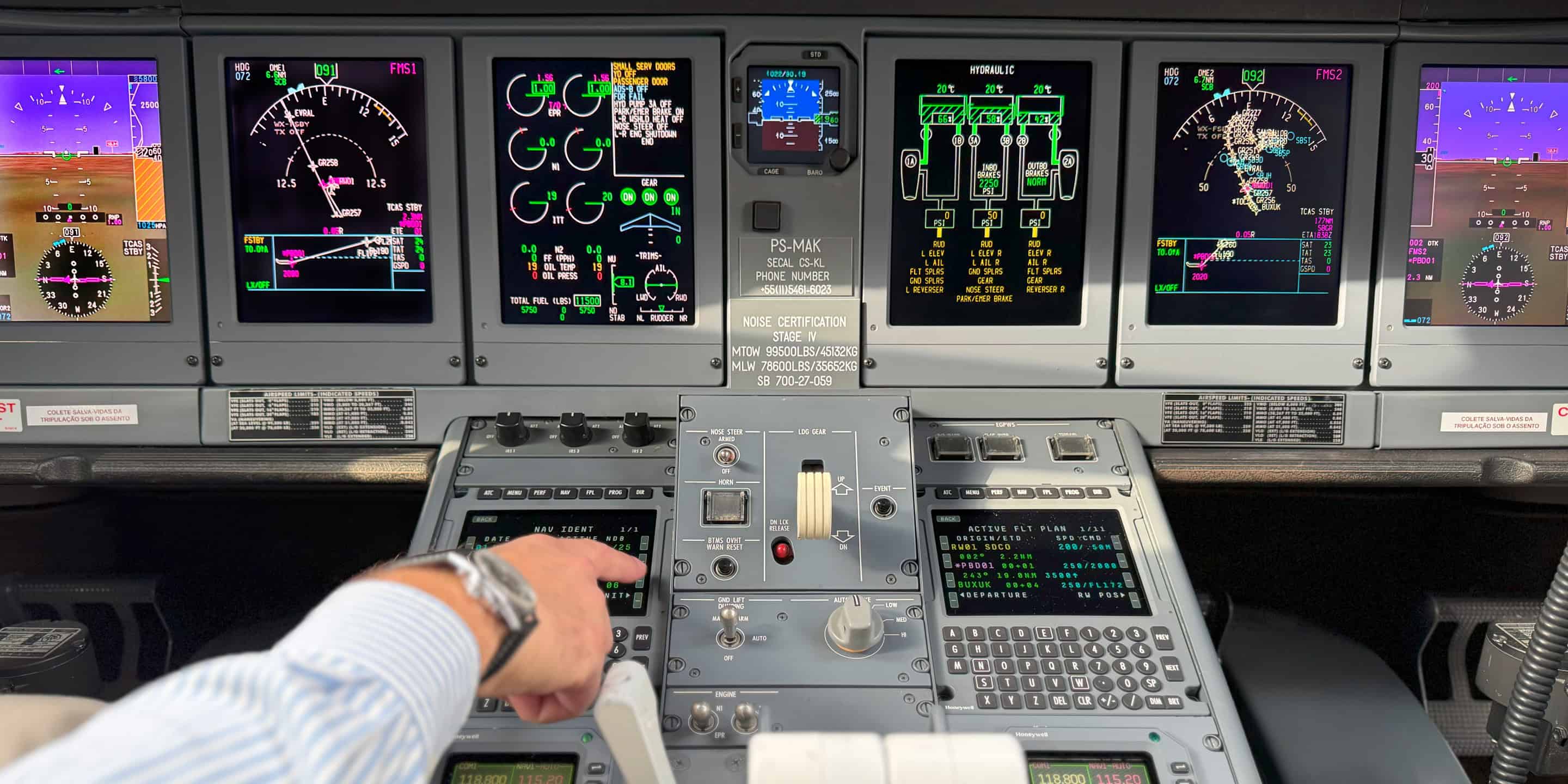 Inside a cockpit, a man operates a plane, focused on various screens that show essential flight information.