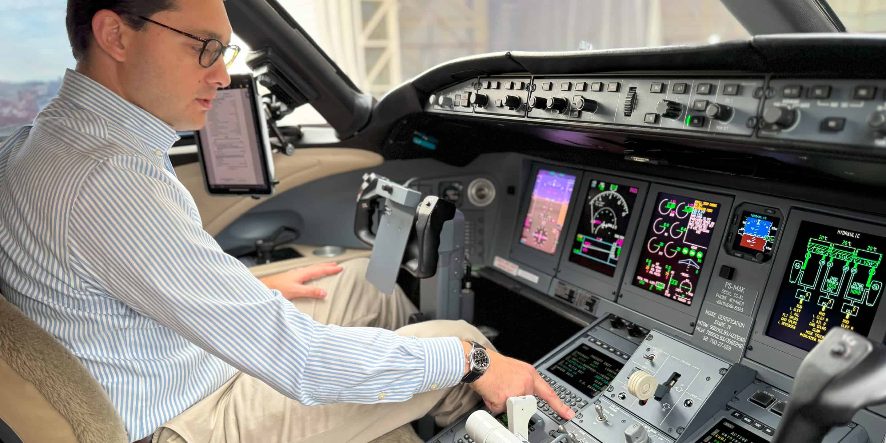 A man seated in the cockpit of an airplane, focused on the controls and instruments in front of him.